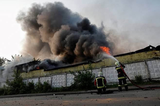 10일(현지시간) 우크라이나 수도 키이우에서 러시아의 드론(무인기) 공격으로 화재가 발생한 건물에 소방관들이 소방호스로 물을 뿌리고 있다. /로이터=뉴스1