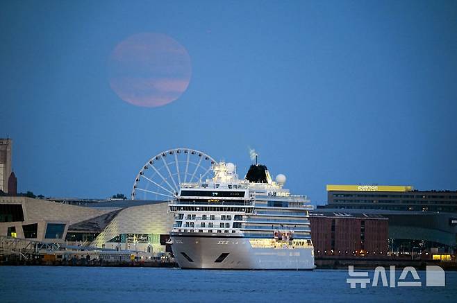 [리버풀=AP/뉴시스] 10일(현지 시간) 영국 머지사이드 리버풀 하늘에 스트로베리 문이 떠오르고 있다. 스트로베리 문은 북미 원주들이 딸기를 수확하는 시기인 6월에 뜨는 달을 의미한다. 2025.06.11.<font style="vertical-align: inherit;"><font style="vertical-align: inherit;"></font></font>