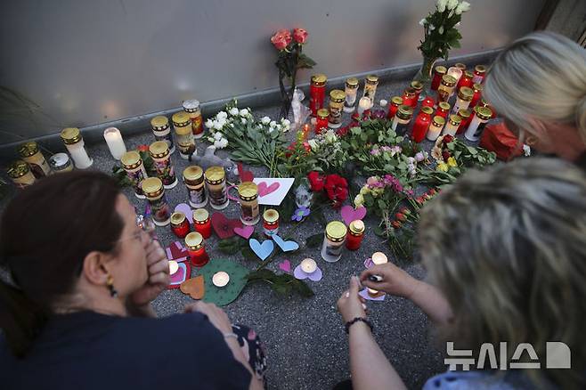 <font style="vertical-align: inherit;"><font style="vertical-align: inherit;"></font></font><font style="vertical-align: inherit;"><font style="vertical-align: inherit;">[그라츠=AP/뉴시스] 10일(현지 시간) 오스트리아 그라츠의 한 고등학교에서 총기 난사 사건이 발생한 후 한 남성이 학교 입구에 희생자를 추모하는 꽃이 놓여져 있다. 2025.06.11.</font></font>