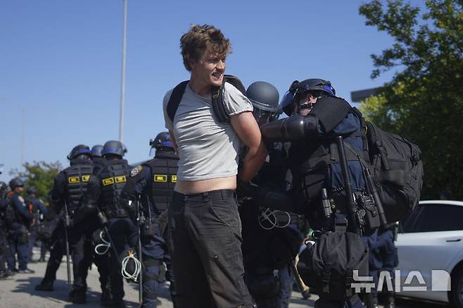 [로스앤젤레스=AP/뉴시스] 10일(현지 시간) 미 캘리포니아주 로스앤젤레스에서 캘리포니아 고속도로 순찰대 소속 경찰이 불법 이민자 단속에 반대하는 한 시위 참가자를 체포하고 있다. 2025.06.11.