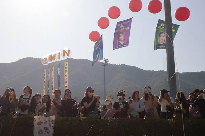 그룹 방탄소년단(BTS)의 팬덤 아미가 11일 경기도 연천군 연천공설운동장에서 이날 전역하는 BTS 지민·정국을 기다리며 환하게 웃고 있다. 연합뉴스