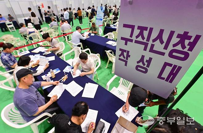 12일 오후 평택시 이충문화체육센터에서 열린 '2025년 상반기 평택시 일자리박람회'를 방문한 시민들이 구직신청서를 작성하고 있다. 임채운기자