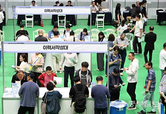 12일 오후 평택시 이충문화체육센터에서 열린 '2025년 상반기 평택시 일자리박람회'를 방문한 시민들이 이력서를 작성하고 있다. 임채운기자