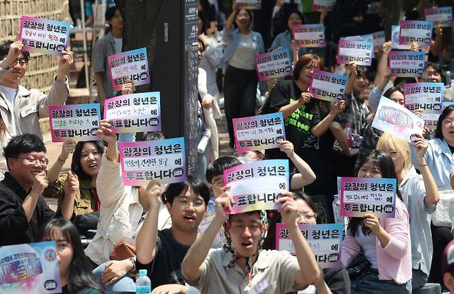 중구 덕수궁 돌담길에서 열린 ‘다시 만들 세계 포럼’ 청년·대학생·청소년 1000인 원탁회의에서 참가자들이 직접 작성한 손팻말을 들어 올리고 있다. (사진=연합뉴스)