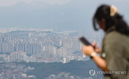 한 시민이 도심 아파트 밀집 지역을 바라보고 있다.<연합뉴스>