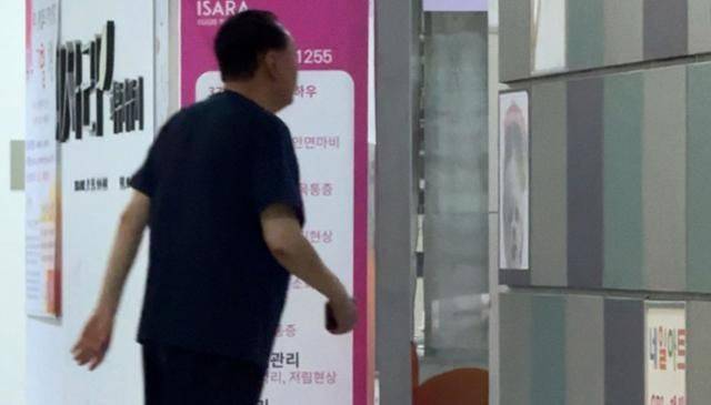 윤석열 전 대통령에 대한 경찰 특별수사단의 2차 출석 요구일인 12일 오전 윤 전 대통령이 소환 통보에 응하지 않은 채 반바지 차림으로 서울 서초구 아크로비스타 상가를 활보하고 있다. 사진=한국일보 사진 캡처