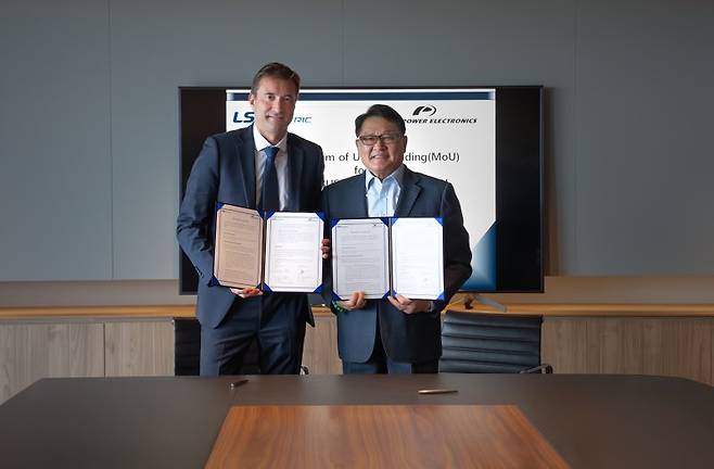 구자균 LS일렉트릭 회장(오른쪽)과 데이비드 살보 파워일렉트로닉스 최고경영자가 최근 전력기기 공급 사업 협력 양해각서를 체결한 후 기념촬영을 하고 있다. LS일렉트릭 제공