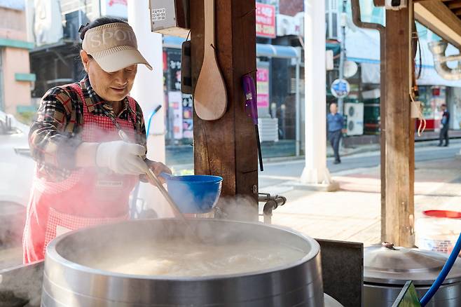 A restaurant staff member boils someori gukbap, or cow head soup, in a large pot. [JANGHEUNG COUNTY OFFICE]
