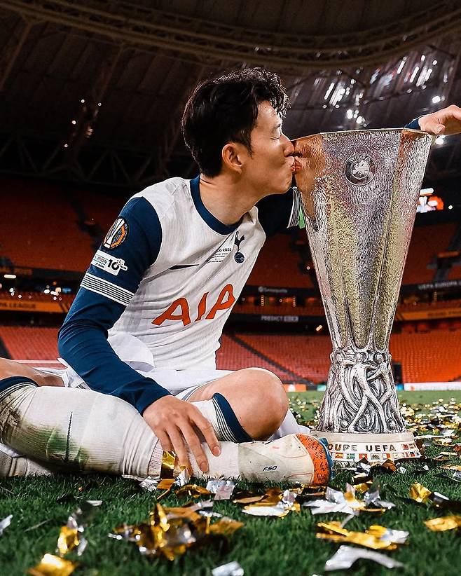 토트넘 주장 손흥민이 지난달 22일(한국시간) 에스타디오 산 마메스에서 열린 맨체스터 유나이티드와 UEL 결승전이 종료된 이후 그라운드에 앉아 우승트로피에 입을 맞추고 있다. 사진출처｜토트넘 페이스북