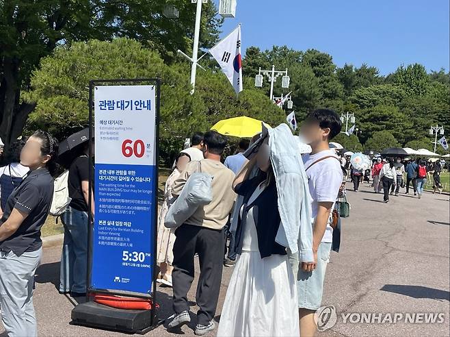 청와대 관람객 대기줄 (서울=연합뉴스) 최혜정 인턴기자 = 지난 11일 청와대 본관 입장을 위한 대기줄이 길게 늘어섰다. 대기줄 초반에는 '관람 대기 안내 60분'이 적힌 안내판에 세워져 있었다. 2025.6.12