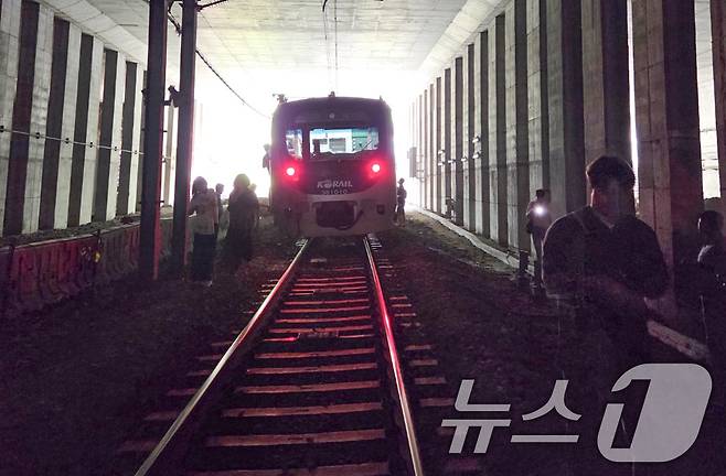 13일 오전 경의중앙선 신촌역 인근에서 사다리차 전도사고가 발생해 가좌역~신촌역 구간이 양방향 통제된 가운데 서울역행 경의중앙선 열차에 탑승한 승객들이 열차에서 내려 선로를 따라 대피하고 있다. (독자 제공, 재판매 및 DB금지)
