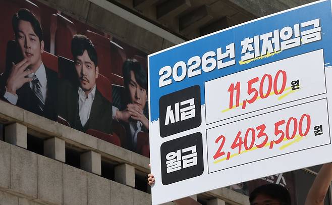 모두를 위한 최저임금 운동본부 회원들이 11일 오전 서울 종로구 세종문화회관 계단에서 기자회견을 열고 내년도 최저임금으로 시급 1만1500원을 요구하며 퍼포먼스를 하고 있다./뉴스1