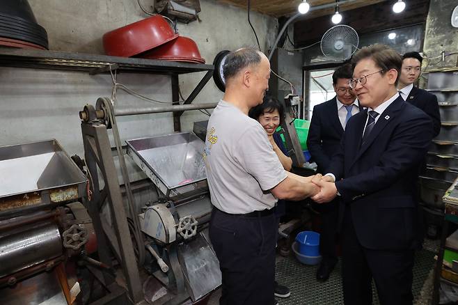 이재명 대통령이 13일 기본소득 실시지역 현황점검을 위해 방문한 경기도 연천군의 한 방앗간에서 주인과 대화하고 있다. /연합뉴스