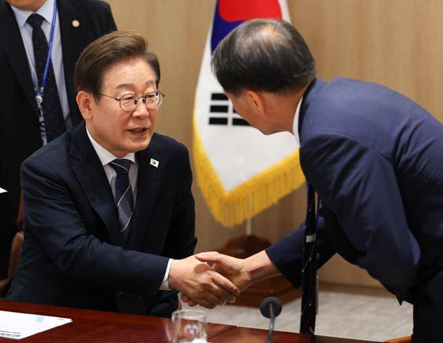 이재명 대통령이 13일 서울 용산 대통령실에서 열린 이스라엘-이란 공습관련 대통령실 안보경제 긴급점검회의에서 새로 임명된 송기호 국정상황실장과 악수하고 있다. 뉴시스