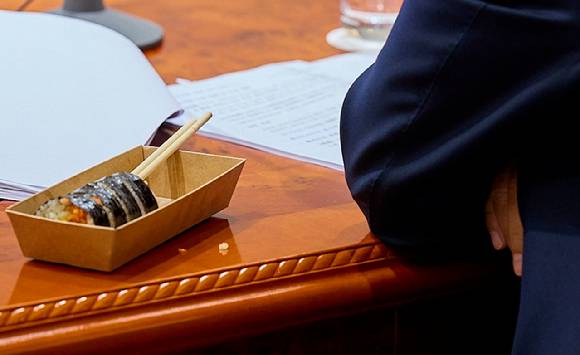 이재명 대통령이 지난 5일 서울 용산 대통령실 청사에서 김밥으로 점심을 먹으며 국무회의를 이어가고 있다.  [사진=대통령실]