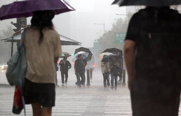 서울 광화문사거리에서 시민들이 우산을 쓴 채 횡단보도를 건너기 위해 기다리고 있다.. [사진=연합뉴스]