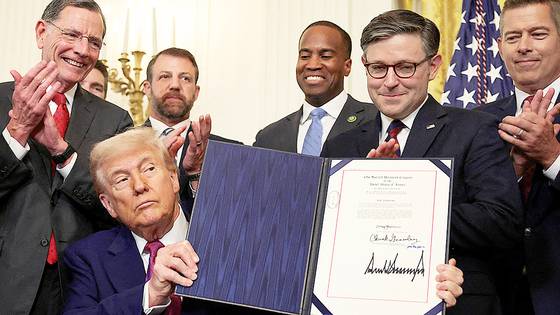 도널드 트럼프 미국 대통령이 12일(현지시간) 백악관에서 캘리포니아의 전기차 의무화 계획에 대한 의회의 승인을 철회하는 결의안에 서명한 뒤 이를 들어보이고 있다. 로이터=연합뉴스