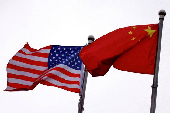 Chinese and U.S. flags flutter outside the building of an American company in Beijing, China on April 8. [REUTERS/YONHAP]