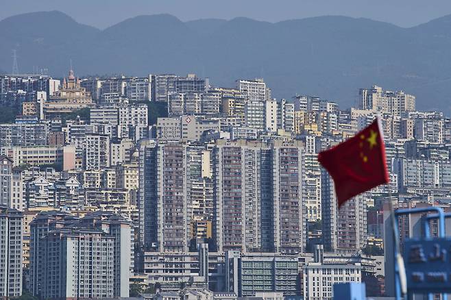 A Chinese flag flutters against high-rise residential buildings in Wushan county in southwest China's Chongqing Municipality on May 21. [AP/YONHAP]