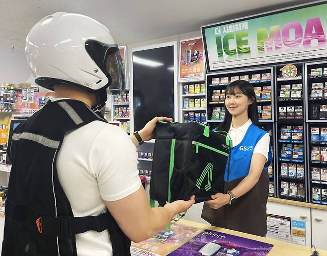 배달 라이더가 편의점에서 소비자가 주문한 상품을 픽업하고 있다. GS리테일