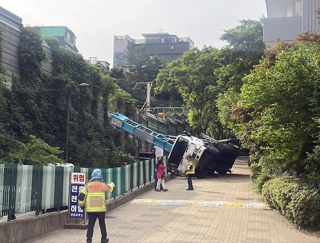 13일 오전 8시 20분께 서울 경의중앙선 가좌역∼신촌역 구간 사다리차 전도 사고로 인해 전기공급 장애가 발생해 열차 운행이 지연되고 있다. 사진은 전도된 사다리차. 연합뉴스