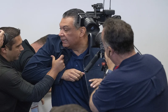 알렉스 파디야 미 상원의원이 기자회견장에서 강제로 끌어내지고 있다. [사진 = AP]