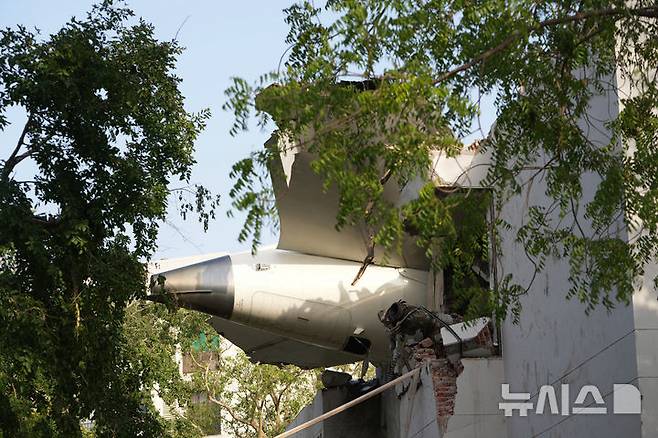 [아마다바드=AP/뉴시스] 12일(현지 시간) 인도 구자라트주 아마다바드에서 발생한 여객기 추락 사고 현장에 기체 꼬리 부분이 건물에 박혀 있다. 이날 아마다바드 공항에서 이륙한 영국행 에어인디아 AI171편 여객기가 추락해 탑승자 242명 가운데 1명을 제외한 전원이 숨졌으며, 추락 현장의 학생 등 약 50명도 사망한 것으로 전해졌다. 2025.06.13.