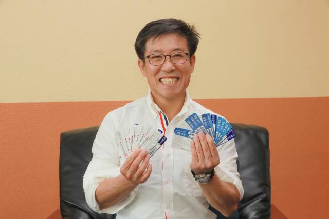 헌혈왕 송태규 시인이 그동안 모은 헌혈증을 양손 가득 들고 환하게 웃고 있다. 사진 제공=본인