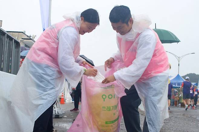 위아런 포항 러닝크루 회원들이 행사 후 행사장 주변의 쓰레기를 밝은 얼굴로 치우고 있다. /임창희 기자
