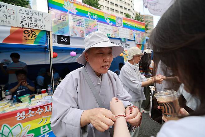 26회 서울퀴어퍼레이드에 참가한 성소수자불교모임 ‘불반’ 혜도 스님이 참가자에게 팔찌를 채워주고 있다. 정용일 선임기자 yongil@hani.co.kr