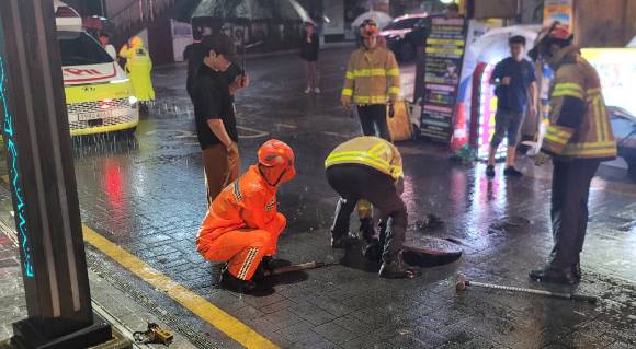 맨홀 안전조치 하는 소방대원. [사진=연합뉴스(부산소방재난본부 제공)]