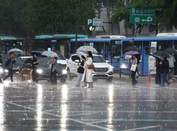 서울 광화문사거리에서 시민들이 우산을 쓴 채 횡단보도를 건너고 있다. [사진=연합뉴스]