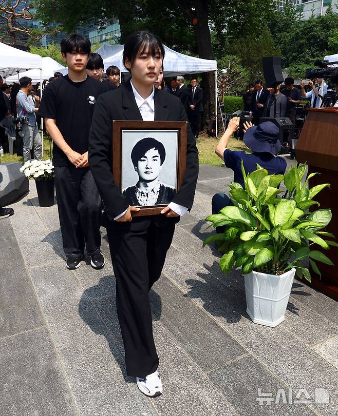 [서울=뉴시스] 박주성 기자 = 9일 서울 서대문구 연세대학교 이한열동산에서 열린 제38주기 이한열 추모식에서 김민결 제38주기 이한열학생추모기획단장을 비롯한 학생들이 이한열 열사 영정을 옮기고 있다. 2025.06.09. park7691@newsis.com