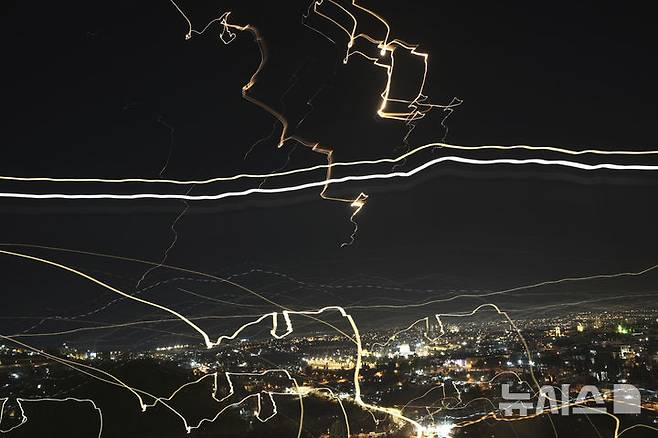 [예루살렘=AP/뉴시스]이스라엘 예루살렘 상공에서 13일 밤(현지시각) 이란 미사일과 이스라엘 요격 미사일이 날아다니는 장면. 느린 셔터 속도로 촬영한 것이다. 이란이 14일 새벽 2차 미사일 공격을 시작했다. 2025.6.14.