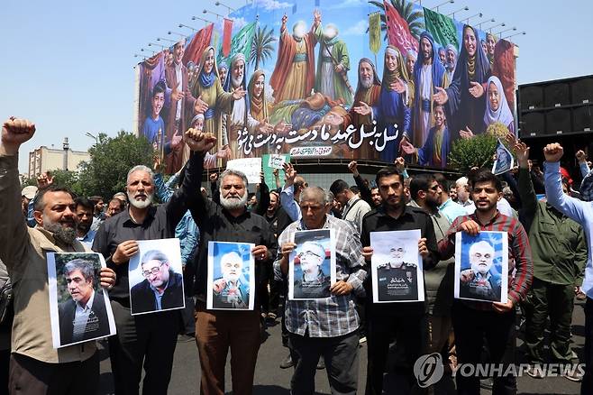 사망한 이란 핵과학자와 군 고위부 사진 들고 있는 시위대 (테헤란 EPA=연합뉴스) 13일(현지시간) 이란 수도 테헤란에서 시위대가 이스라엘의 공격을 규탄하는 시위를 벌이고 있다. 2025.06.14