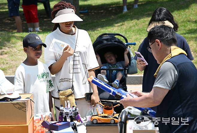 2025 송도굿마켓 행사에서 한 외국인가족이 장난감총을 구매 하고 있다.정선식기자