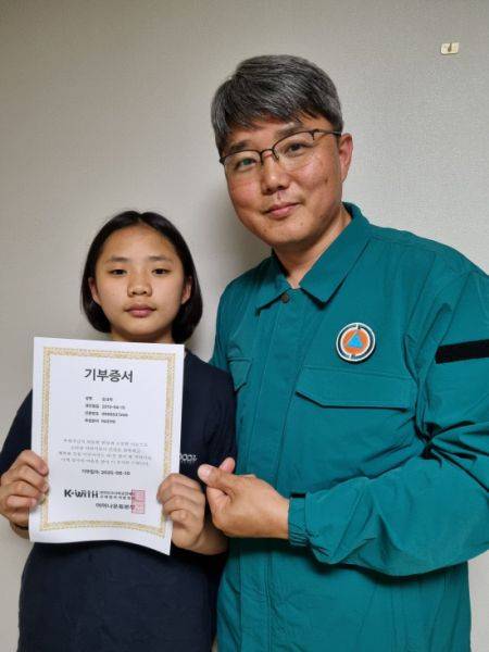 지난 11일 모발기부에 참여한 솔개여단 김정규 사무관의 자녀 김규리 양이 모발기부증서를 들고 기념촬영을 하고 있다. 사진=39사단