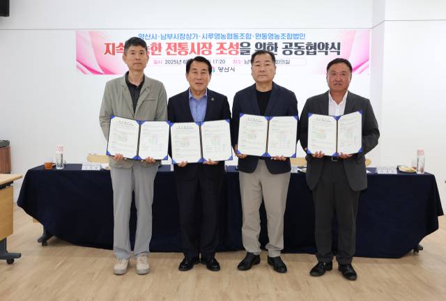 양산시는 지난 13일 남부시장에서 남부시장상가상인회와 시루영농조합법인, 원동영농조합법인과 전통시장 활성화와 지역경제의 지속 가능한 발전을 위한 4자 업무협약을 체결한 뒤 기념사진을 찍고 있다, 양산시 제공