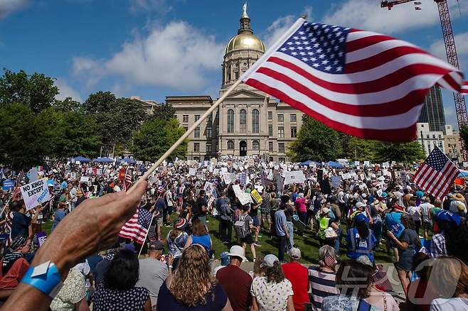 14일(현지시간) 도널드 트럼프 미국 대통령이 워싱턴DC에서 미 육군 창설 250주년 군사 퍼레이드를 주재하는 가운데 이날 조지아주 애틀랜타의 리버티 플라자에서 사람들이 '노킹스'(No Kings) 시위에 참여하고 있다. 미국 국기의 날(Flag Day)인 이날은 트럼프 대통령의 79번째 생일이기도 하다. 트럼프 정권에 반대하는 이번 노킹스 시위는 미 50개 모든 주에서 진행되며, 1800개 이상의 집회가 열릴 예정이다. 2025.06.14 ⓒAFP=뉴스1 ⓒ News1 류정민 특파원