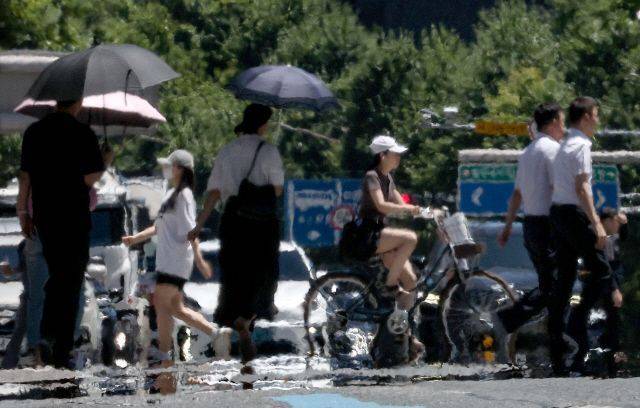 전국 대부분 지역에 폭염 특보가 발효된 지난해 7월 31일 오후 대구 중구 공평네거리에서 시민들이 열기로 가득한 도로 위를 걸어가고 있다.ⓒ연합뉴스