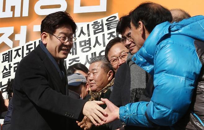 이재명 대통령이 첫 번째 대선에 도전한 2017년 1월23일 과거 ‘소년공’으로 일했던 경기 성남시 오리엔트 시계 공장 마당에서 대선 출마 선언을 한 뒤, 자신과 함께 시계공장에서 일했던 동료들을 무대 위로 올라오게 해 인사를 나누고 있다. 한겨레 자료사진