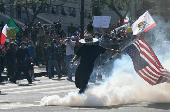 워싱턴에서 열병식이 열린 14일(현지시간) 로스앤젤레스에서 열린 '노 킹스' 시위에서 경찰이 발사한 최루탄이 최루 가스를 내뿜고 있다. AFP=연합뉴스