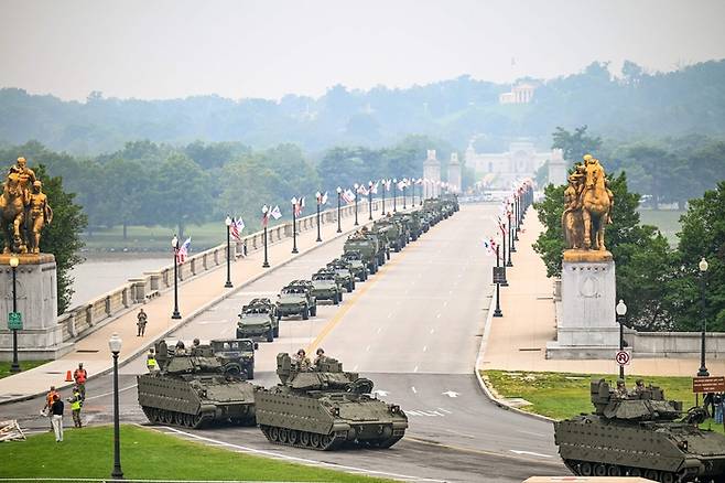 2025년 6월 14일, 미국 워싱턴 D.C.에서 열린 육군 창설 250주년 기념 퍼레이드 도중, 미 육군 병력과 장갑차들이 메모리얼 브리지를 지나가고 있다.
토요일, 도널드 트럼프 미국 대통령은 79번째 생일을 맞아 오랫동안 꿈꿔온 군사 퍼레이드를 마음껏 즐겼으며, 동시에 전국 곳곳에서는 그를 독재자라고 규탄하는 시위가 벌어졌다. 이는 그가 권좌에 복귀한 이후 최대 규모의 시위였다. [사진 = AFP 연합뉴스]