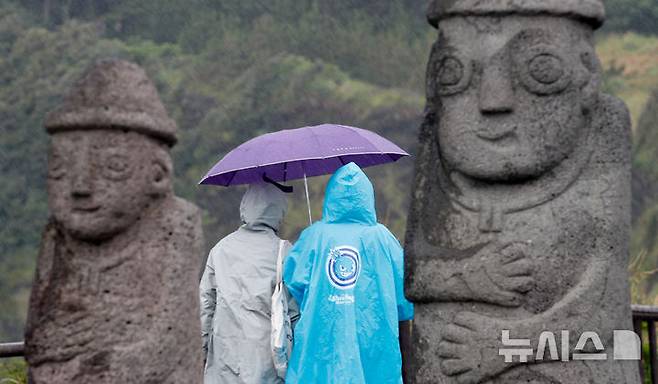 [서귀포=뉴시스] 우장호 기자 = 올해 첫 장맛비가 내리는 지난 12일 오전 제주 서귀포시 대정읍 송악산 둘레길에서 우산을 쓴 관광객들이 걸어가고 있다. 2025.06.12. woo1223@newsis.com