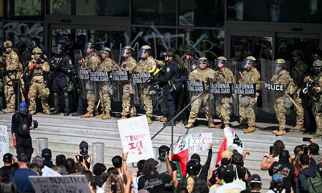 LA 도심에서 시민들이 트럼프 정부의 반이민 정책 시위를 벌이는 가운데 주방위군이 이를 저지하고 있다. 연합뉴스