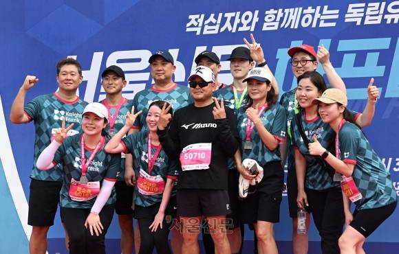 17일 오전 서울 마포구 상암 평화의공원 평화광장에서 열린 2025서울신문하프마라톤대회에서 참가자들이 이봉주 선수와 기념촬영을 하고 있다. 2025.5.17. 도준석 전문기자