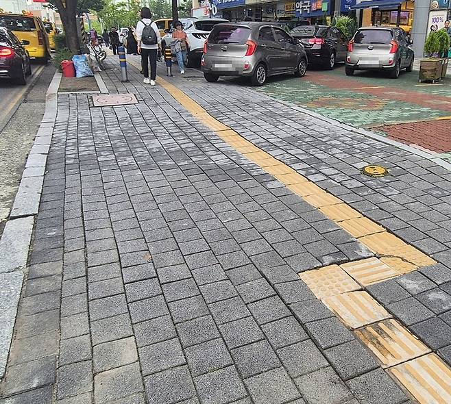 16일 울산 남구 야음동 일대 도로 진출입로가 반복적인 차량 통행으로 보도블럭과 점자블럭이 깨지거나 들뜬 채 방치돼 있다.