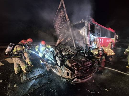 16일 새벽 1시37분께 충남 당진시 고대면 진관리의 한 주유소에 승용차가 돌진해 버스와 충돌한 후 뒤집혀 불이 나 소방대원들이 진화에 나서고 있다. (사진=당진소방서 제공)
