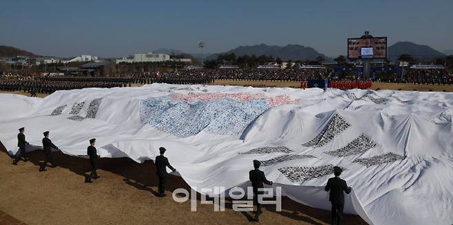 지난 2월 28일 김선호 국방부 장관 직무대행 주관으로 충북 괴산군 소재 육군학생군사학교에서 열린 ‘2025년 대한민국 학군장교 임관식’에서 충성다짐 퍼포먼스로 임관 소위들이 손도장을 찍어 만든 대형태극기를 펼치고 있다. (사진=육군)