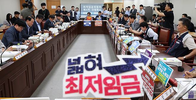 지난 10일 세종시 정부세종청사에서 열린 최저임금위원회 제4차 전원회의에 참석한 사용자위원과 근로자원들이 각자의 의견이 적힌 손팻말과 머리띠를 착용한 채 회의를 시작하고 있다. 2025.6.10/뉴스1 ⓒ News1 김기남 기자
